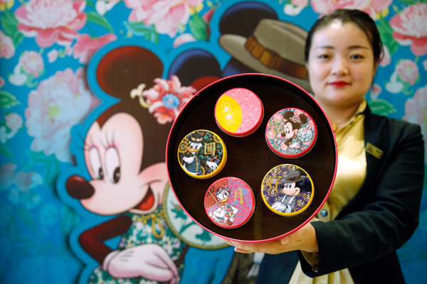 A worker displays Disney-themed mooncakes at a store in Shanghai earlier this month. Tang Yanjun/China News Service A worker displays Disney-themed mooncakes at a store in Shanghai earlier this month. Tang Yanjun/China News Service