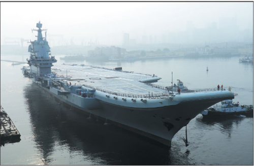 China's first domestically designed aircraft carrier, which displaces 50,000 metric tons, leaves the Dalian Shipbuilding Industry's shipyard in Liaoning province on Sunday. (Li Gang/For China Daily) China's first domestically designed aircraft carrier, which displaces 50,000 metric tons, leaves the Dalian Shipbuilding Industry's shipyard in Liaoning province on Sunday. (Li Gang/For China Daily)